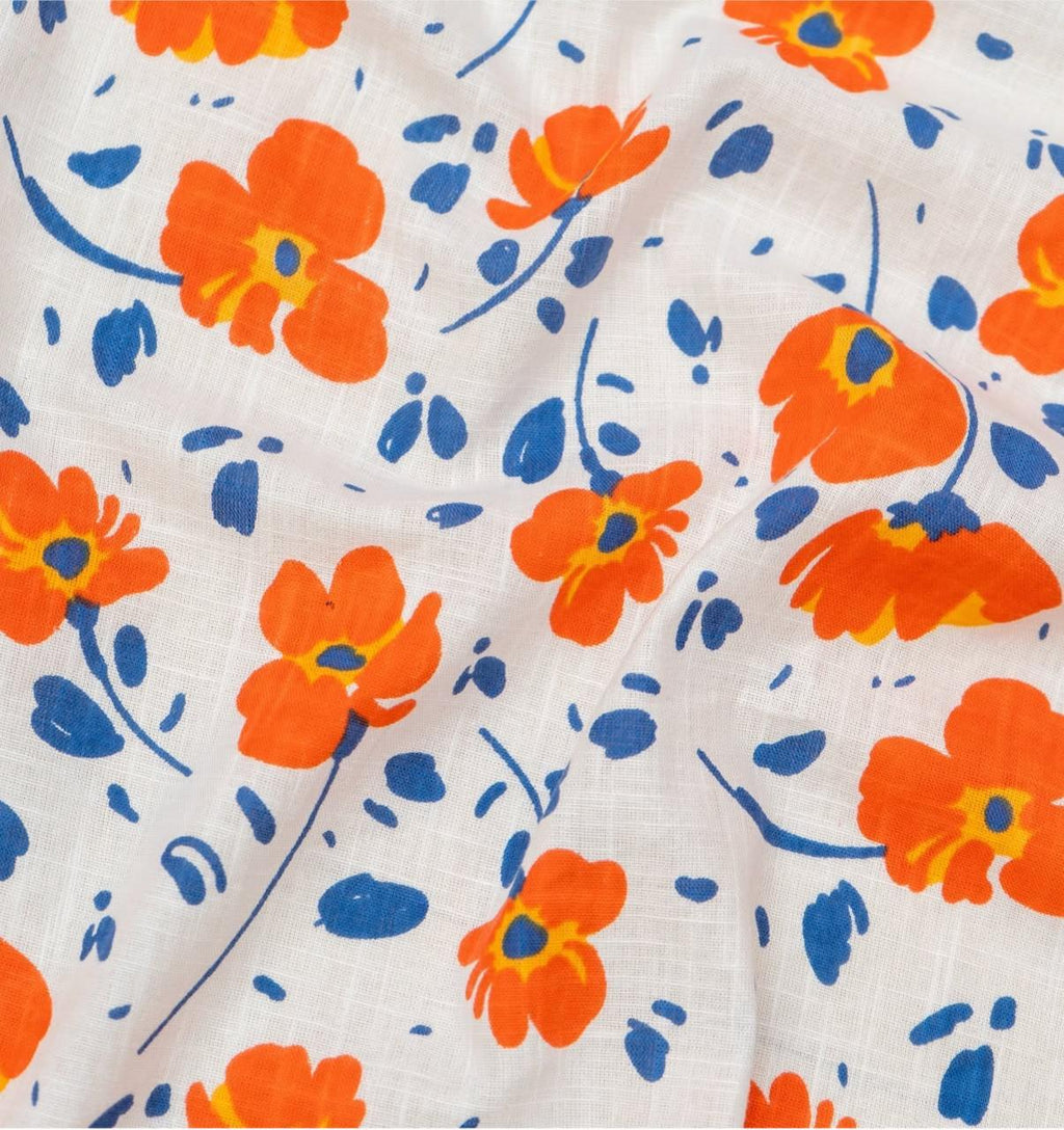 Shinyora Sunflora maxi dress fabric featuring a vibrant orange and blue botanical poppy print on white cotton-linen.