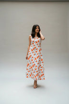 Shinyora Sunflora maxi dress in white cotton-linen with an orange botanical poppy print and A-line silhouette
